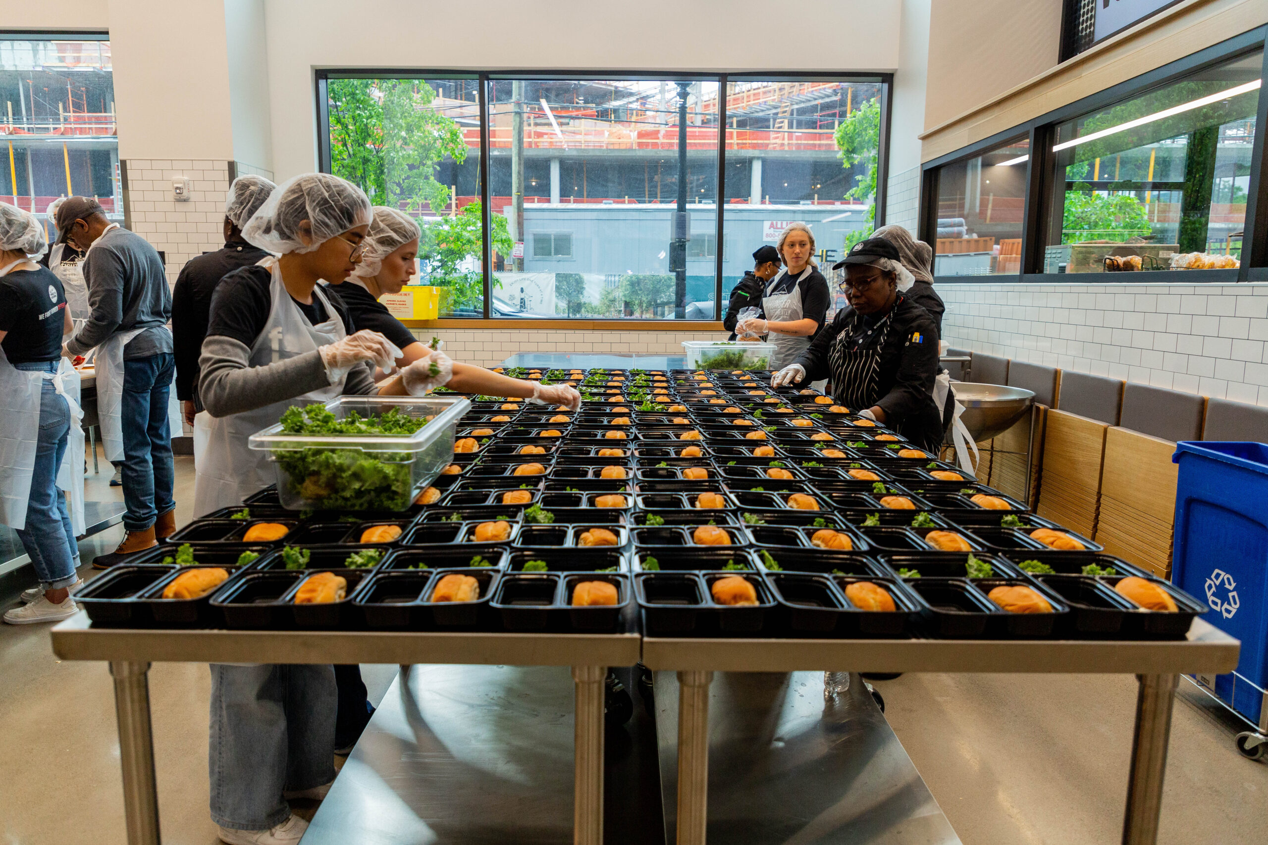 Volunteers in the CoBank Volunteer Zone fill trays for meals