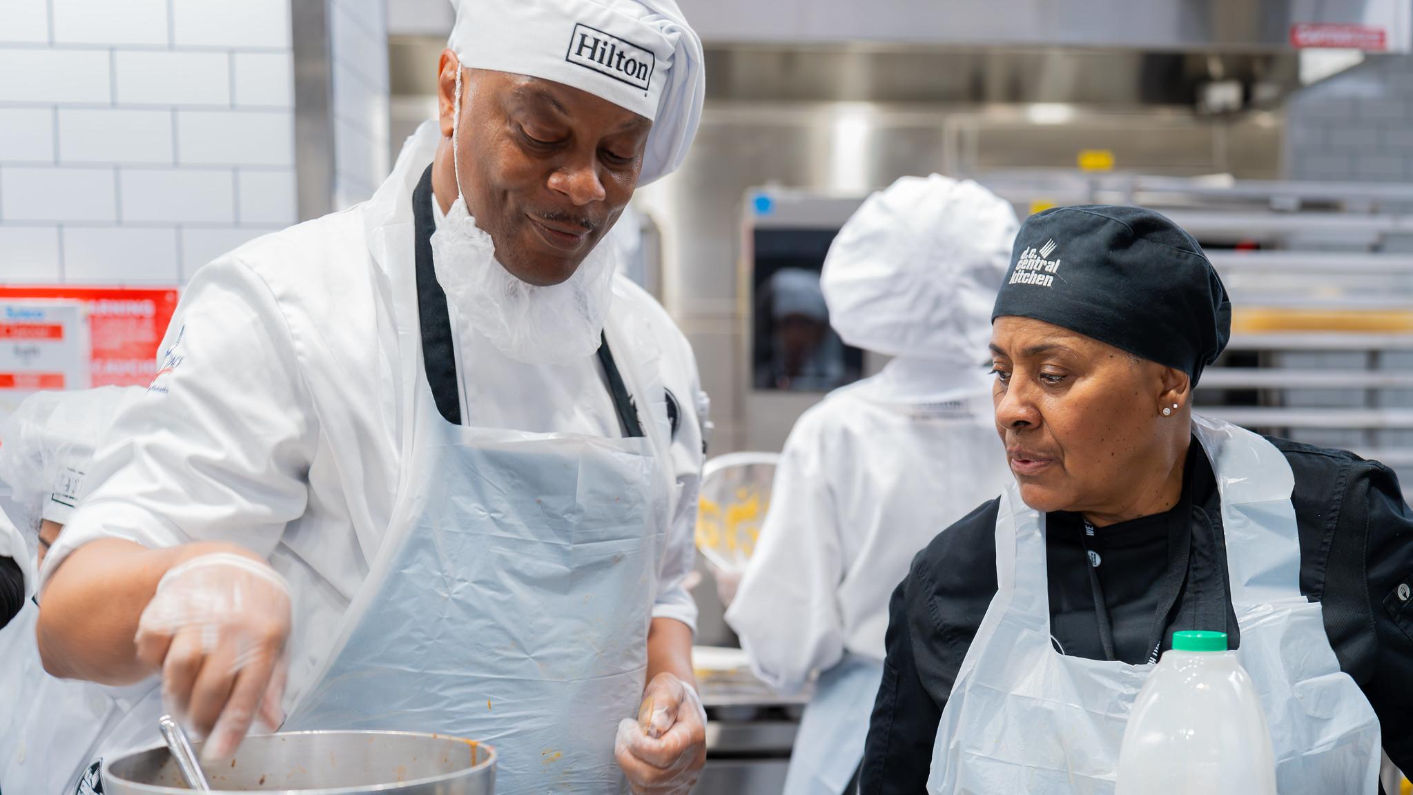 A Culinary Jobs Traning student and DC Central Kitchen instructor working in the kitchen