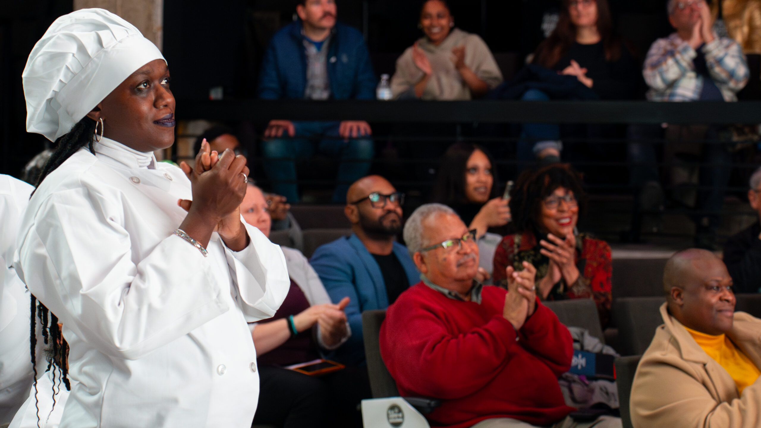 A Culinary Job Training graduate clapping for a fellow student at graduation.