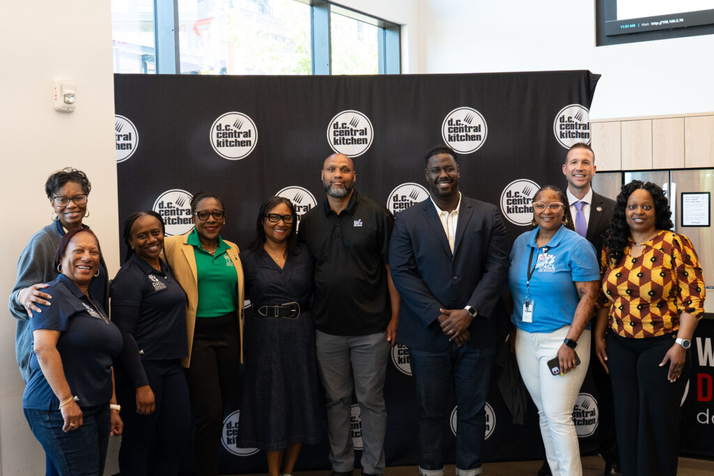 Representatives from DC's Department of Aging and Community Living and the Mayor's Office of Veterans Affairs join DoorDash's Darrell Davis, DCCK's Alex Moore, and DCCK's Community Meals team of Crystal Nicholas and Michael McCoy to celebrate the expansion of home delivered meals to seniors and veterans.