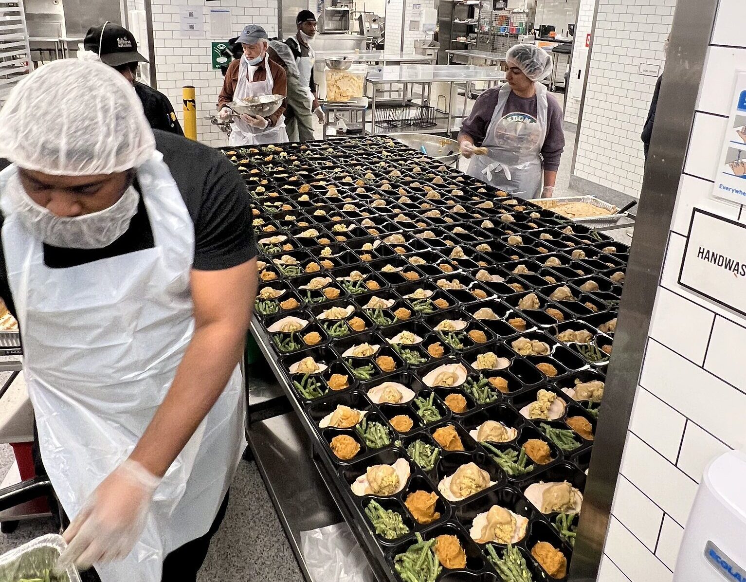 A DC Central Kitchen volunteer assembling a Thanksgiving meal