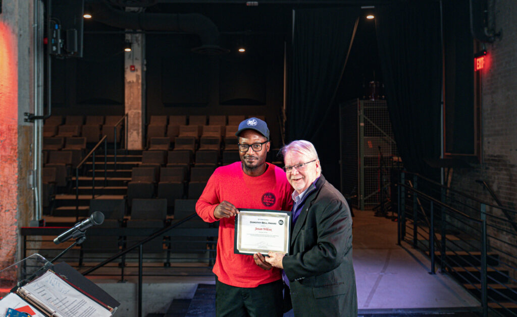 DC Central Kitchen Cafe Employee Jovan receiving an award on stage