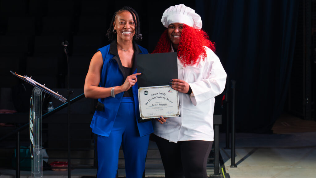 A student receives an award at a Culinary Job Training graduation