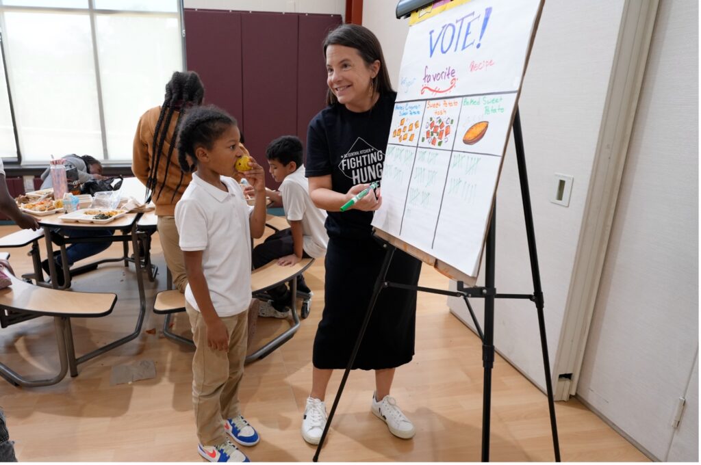 DCCK Chief Operating Officer Lowrey Redmond tallies students' votes during a Fresh Feature Friday at C.W. Harris Elementary School