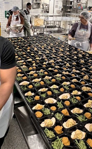 A DC Central Kitchen volunteer assembling a Thanksgiving meal